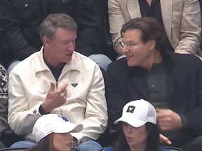 Wayne Gretzky and Vancouver Canucks owner Francesco Aquilini chat while sitting in the Rogers Arena crowd during the game against the Ottawa Senators on Tuesday.