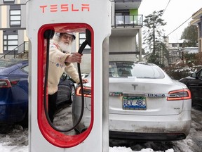 Tesla electric vehicle owner Bruce Stout with his car at a Tesla fast-charging station in North Vancouver on Jan. 19.