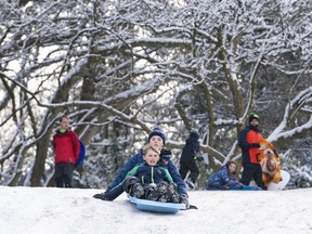 Here's a handy list of the schools around Metro Vancouver that have reported closures on Jan. 17, 2024. George (front) and Lewis Sale slide down a hill at QE Park while enjoying a snow day in Vancouver in this 2019 file photo.