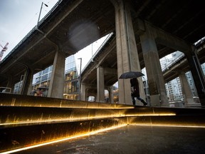 A person carries an umbrella as heavy rain falls in Vancouver, B.C., Tuesday, Jan. 5, 2021. Balmy weather and a series of rainstorms forecast for British Columbia's South Coast have set off flood advisories for rivers, streams and low-lying areas.THE CANADIAN PRESS/Darryl Dyck