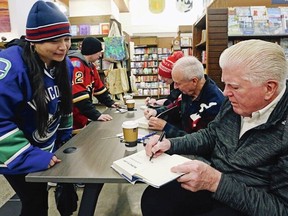 Leah Mar and Justin Creurer get memorabilia signed by Ken Reid, Ron MacLean and Brian Burke, right, at Munro?s Bookse on Friday ahead of today?s Hockey Day in Canada in Victoria. ADRIAN LAM, TIMES COLONIST