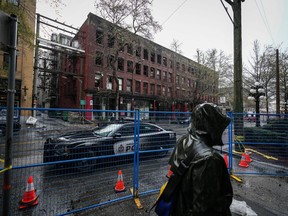 A coroner's inquest has been told that a Vancouver rooming house where a fire killed two people in 2022 had a chained door, as relatives testified about the devastating impact of the blaze. A police officer sits in a vehicle outside of the Winters Hotel that was destroyed by fire in Vancouver on Tuesday, April 12, 2022.