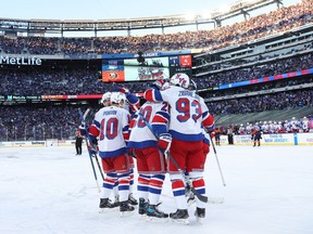 Artemi Panarin #10 of the New York Rangers is congratulated by his teammates after scoring a goal against the New York Islanders during the second period during the 2024 Navy Federal Credit Union Stadium Series at MetLife Stadium on February 18, 2024 in East Rutherford, New Jersey.