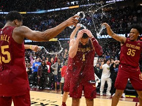 Max Strus (1) of the Cleveland Cavaliers is showered with water by his teammates after making a half-court buzzer-beater to defeat the Dallas Mavericks at Rocket Mortgage Fieldhouse on Tuesday, Feb. 27, 2024, in Cleveland, Ohio. The Cavaliers defeated the Mavericks 121-119.