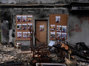 Photographs of Israeli hostages being held in the Gaza Strip are placed on a house that was destroyed by Hamas in Kibbutz Be'eri, Israel, Wednesday, Dec. 20, 2023. (AP Photo/Ohad Zwigenberg)