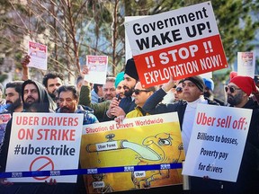 Uber drivers gather Wednesday at Vancouver airport to protest pay and working conditions at the ride-hailing giant.