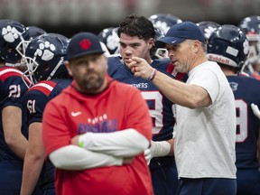 Football player Mark Johnson talks with coach Angus Reid.