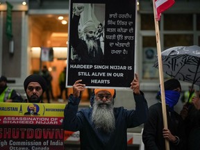 A man holds a sign with a photograph of Hardeep Singh Nijjar during a protest outside the Indian Consulate in Vancouver on Monday, Sept. 25, 2023. The spokesman for a group advocating Sikh independence says that a Metro Vancouver home hit by gunfire on Thursday belonged to a member of the movement.