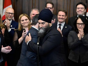 NDP Leader Jagmeet Singh embraces NDP MP Don Davies, critic for health, before a news conference on drug coverage for Canadians, in the foyer of the House of Commons on Parliament Hill in Ottawa, on Thursday, Feb. 29, 2024.
