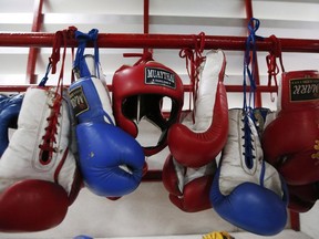 Thai kick-boxing gloves and headgear hang at a training camp in Bangkok, Thailand on Wednesday, Nov. 14, 2018. The mother of a University of British Columbia doctoral student is suing organizers of a martial arts tournament where she says he was battered by an opponent before falling into a "vegetative state."