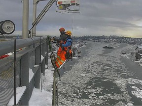 Rope access technicians reload the cable collar system on the Port Mann Bridge during a cold snap in January 2020. The collars help prevent "ice bombs" from detaching and falling onto vehicles below.