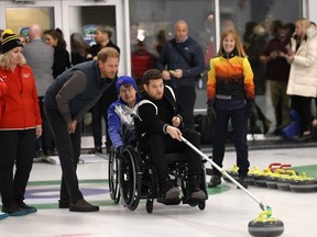 Prince Harry watches Michael Bublé try out wheelchair curling at the Hillcrest Community Centre in Vancouver.