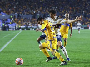 Jesus Angulo of Mexico's Tigres, left, and Brian White of Canada's Vancouver Whitecaps compete for the ball during a CONCACAF Champions Cup soccer match in Monterrey, Mexico, Wednesday, Feb. 14, 2024.