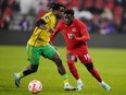 Canada's Alphonso Davies (19) moves past Jamaica's Dexter Lembikisa (2) during first half CONCACAF Nations League quarterfinal soccer action in Toronto on Tuesday, November 21, 2023. Canada fell two places to No. 50, sandwiched between Greece and Cameroon, in the latest FIFA world rankings.