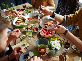 People sitting at dining table and eating. Stock Image. Getty Images/iStock Photo