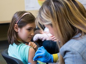 FILE -- A 9-year-old rolls up her sleeve for a vaccination at a clinic in Portland, Ore., Feb. 16, 2019. A measles outbreak continues to spread throughout the United States, new government data shows, with four states recording their first cases of the virus for 2019, bringing the total to 465 cases nationally through the first week of April. (Alisha Jucevic/The New York Times) ORG XMIT: XNYT275