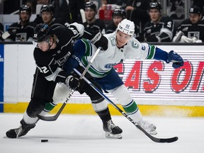 Los Angeles Kings defenceman Brandt Clarke (92) controls the puck away from Vancouver Canucks right wing Vasily Podkolzin (92) during the first period on Tuesday night in Los Angeles