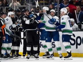 Los Angeles Kings center Pierre-Luc Dubois (80) gets into a fight with Vancouver Canucks defenseman Noah Juulsen (47) during the second period of an NHL hockey game Tuesday, March 5, 2024, in Los Angeles.