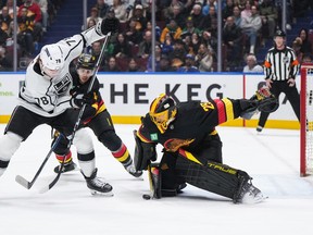 Casey DeSmith (29) stops Los Angeles Kings' Alex Laferriere (78) as Vancouver's Pius Suter (24) defends during the first period at Rogers Arena on Monday night