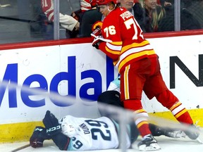 Calgary Flames Martin Pospisil hits Seattle Kraken Vince Dunn from behind at the Scotiabank Saddledome in Calgary on Monday, March 4, 2024.