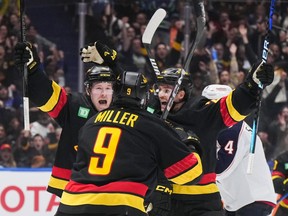Vancouver Canucks' Brock Boeser, Pius Suter and J.T. Miller celebrate Boeser's hat trick goal against the Columbus Blue Jackets in late January.