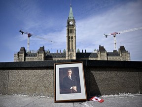 A framed portrait of former prime minister Brian Mulroney leans against the Centennial Flame on Parliament Hill as Canadians mourn his death at the age of 84, in Ottawa, on Friday, March 1, 2024.