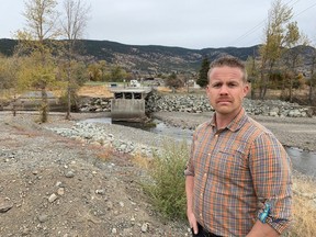 Merritt's director of flood recovery and mitigation, Sean Strang, stands in front of a bridge that was washed out during the flooding on the Coldwater River in November 2021. He said the city is more vulnerable to a major flood today than it was then because dikes haven't been rebuilt or upgraded.