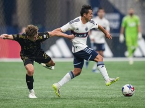 Los Angeles FC's Nathan Ordaz, left, grabs the jersey of Vancouver Whitecaps' Andres Cubas as they vie for the ball during the second half in game 2 of a first-round MLS playoff soccer match, in Vancouver, on Sunday, Nov. 5, 2023. The Whitecaps will renew acquaintances with Los Angeles FC, which ended their playoff run last season, in the Leagues Cup this season.