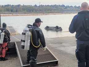 A partially submerged vehicle is towed out of the Fraser River in Coquitlam.