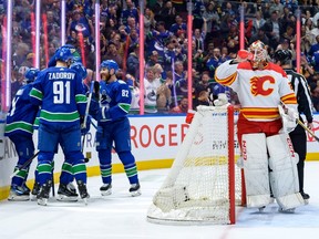 Nils Hoglander is congratulated after scoring a goal against Jacob Markstrom of the Calgary Flames during the first period at Rogers Arena on Tuesday night.