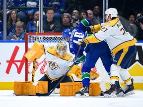 Juuse Saros makes a save on Elias Pettersson during the second period