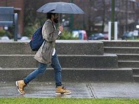 File photo of a man walking in the rain in Vancouver.