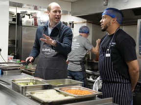 Prince William, Prince of Wales helps make bolognese sauce with head chef Mario Confait, during a visit to Surplus to Supper, in Sunbury-on-Thames on April 18, 2024 in Surrey, England.