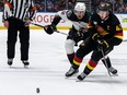 Arizona Coyotes' Josh Doan (91) and Vancouver Canucks' Quinn Hughes (43) vie for the puck during the first period of an NHL hockey game in Vancouver, on Wednesday, April 10, 2024.