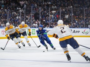 Quinn Hughes rushes thepuck against the Nashville Predators