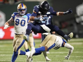 Andrew Harris is leaving football as one the greatest running backs in CFL history. Harris (33) hurdles over Winnipeg Blue Bombers defensive back Brandon Alexander (37) as defensive tackle Casey Sayles (90) looks on during the 109th Grey Cup at Mosaic Stadium in Regina, Sunday, Nov. 20, 2022.