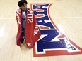 Freed-Hardeman guard Quan Lax wears the championship banner after the NAIA men's national championship college basketball game against Langston, Tuesday, March 26, 2024, in Kansas City, Mo. Freed-Hardeman won 71-67. (AP Photo/Charlie Riedel)