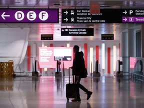 A traveller makes their way through Pearson International Airport in Toronto Monday, Nov. 14, 2022. Police say they've made arrests in a daring theft of nearly $24 million in gold and cash from Toronto's Pearson airport last year.