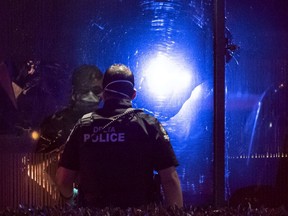 A member of the Delta police looks at a bullet hole in the window of the Manzo Japanese Restaurant where two people were shot at in Richmond on Sept. 18, 2020.