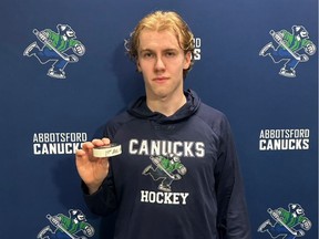Abbotsford Canucks forward Jonathan Lekkerimaki poses with the game puck after scoring his first AHL goal on Saturday night against the Coachella Valley Firebirds at the Abbotsford Centre.