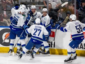 Abbotsford Canucks players celebrate captain Chase Wouters' overtime goal in a series-clinching 2-1 Game 3 win against the Colorado Eagles in the AHL playoffs on Sunday, April 28, 2024