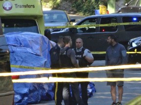 A parked vehicle is covered by a blue tarp as North Vancouver RCMP investigate an apparent homicide on Wellington Drive, east of Sykes Road, on Sept. 29, 2015.