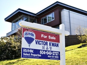 A "For Sale" sign is displayed outside a home in Vancouver, British Columbia