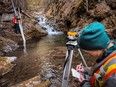 Paige Thurston, Columbia Basin Water Monitoring Framework program manager, right, completes a survey following a hydrometric install on Apex Creek in the Columbia Basin near Nelson, B.C. in this undated handout photo. A trio of experts in British Columbia says persistent drought is exposing cracks in how the province manages water, especially when it's scarce.