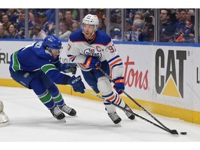 VANCOUVER, BRITISH COLUMBIA - MAY 08: Connor McDavid #97 of the Edmonton Oilers skates with the puck against Carson Soucy #7 of the Vancouver Canucks during the first period in Game One of the Second Round of the 2024 Stanley Cup Playoffs at Rogers Arena on May 08, 2024 in Vancouver, British Columbia.