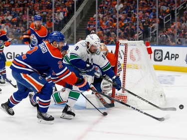 EDMONTON, ALBERTA - MAY 12: Evan Bouchard #2 of the Edmonton Oilers and J.T. Miller #9 of the Vancouver Canucks battle for the puck during the first period in Game Three of the Second Round of the 2024 Stanley Cup Playoffs at Rogers Place on May 12, 2024 in Edmonton, Alberta.