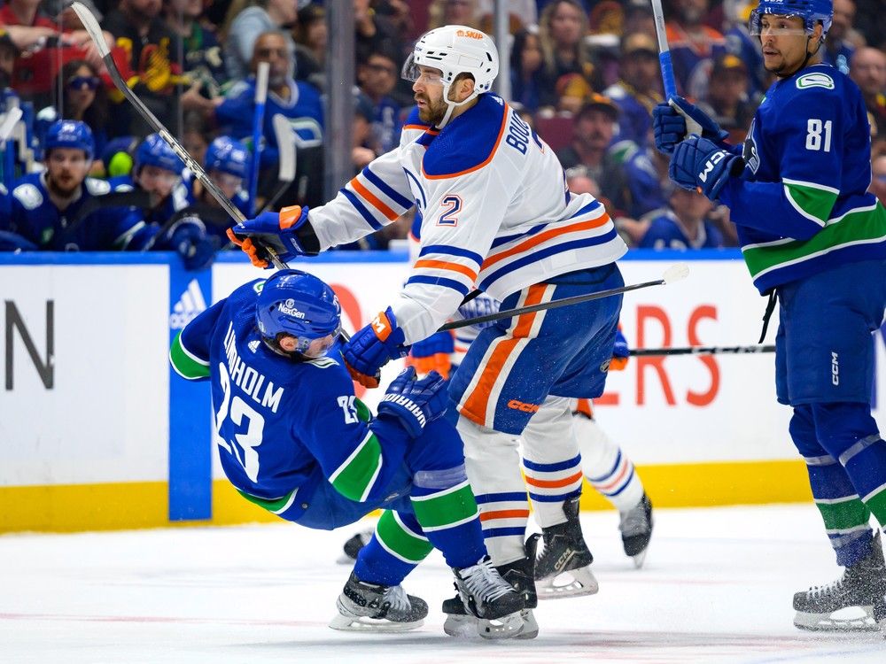 Evan Bouchard #2 of the Edmonton Oilers checks Elias Lindholm #23 of the Vancouver Canucks during the second period in Game Seven of the Second Round of the 2024 Stanley Cup Playoffs at Rogers Arena on May 20, 2024 in Vancouver, British Columbia, Canada.