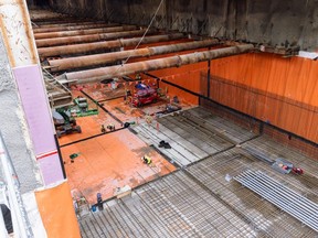 Crews on the Broadway Subway project installing orange waterproofing membrane at the future Oak-VGH Station.