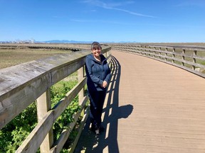 Tsawwassen First Nation Chief Laura Cassidy stands on a boardwalk over the tidal flats, with Roberts Bank Superport in background. The First Nation has overseen construction of a large shopping centre, market housing for almost 4,000 people and several giant warehouses.