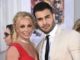 FILE - Britney Spears and Sam Asghari appear at the Los Angeles premiere of "Once Upon a Time in Hollywood" on July 22, 2019. Spears has reached a divorce settlement with her soon-to-be-ex-husband Asghari.
